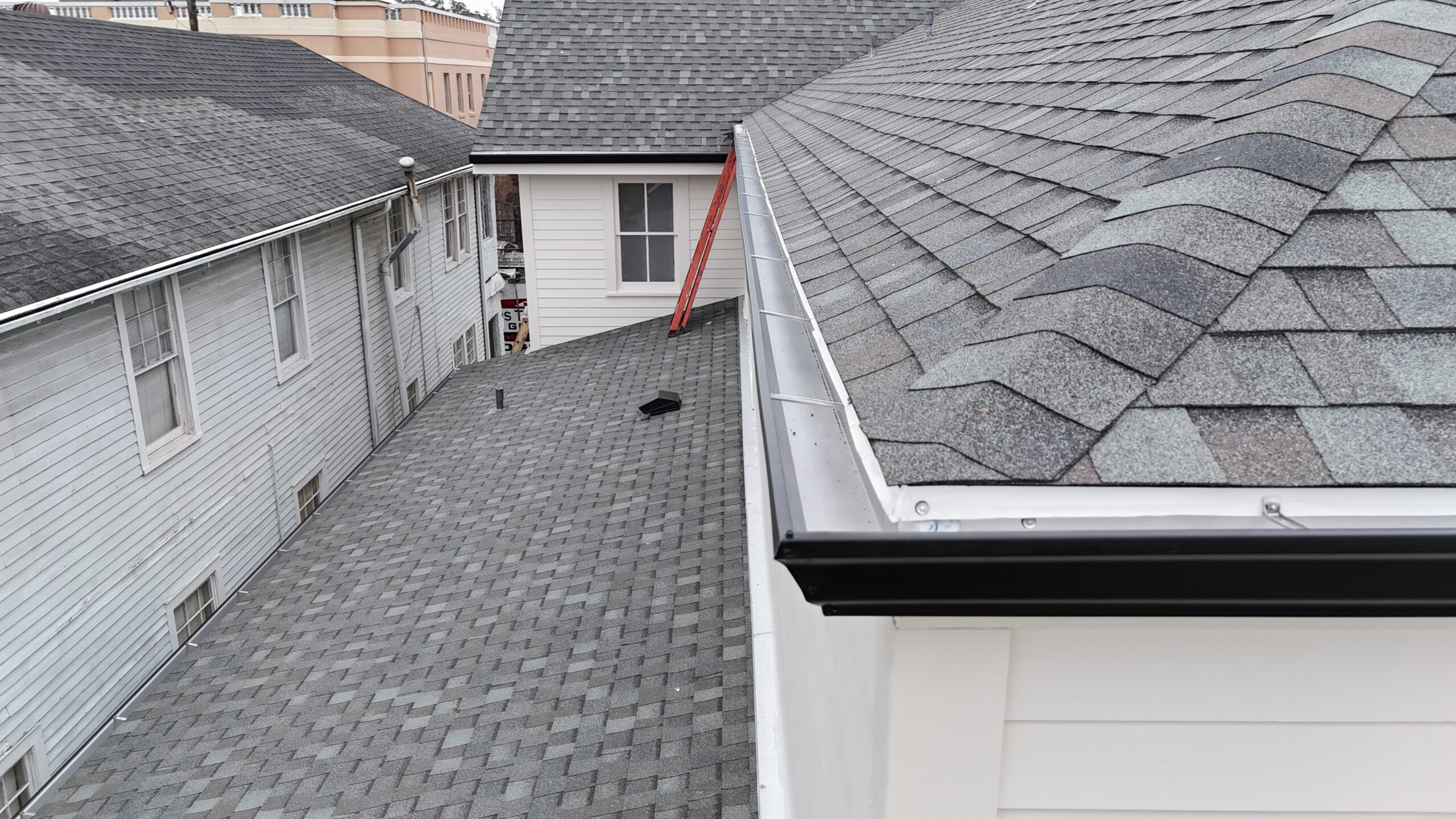 Roofing crew installing starter course shingles along the eave of a home in New Orleans