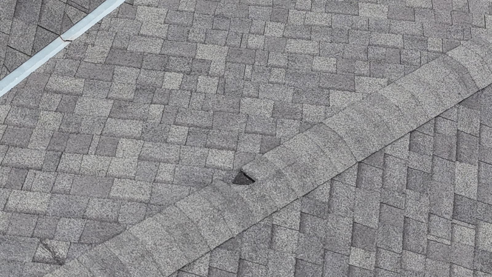 Close-up detail of an architectural asphalt shingle roof with ridge cap shingles
